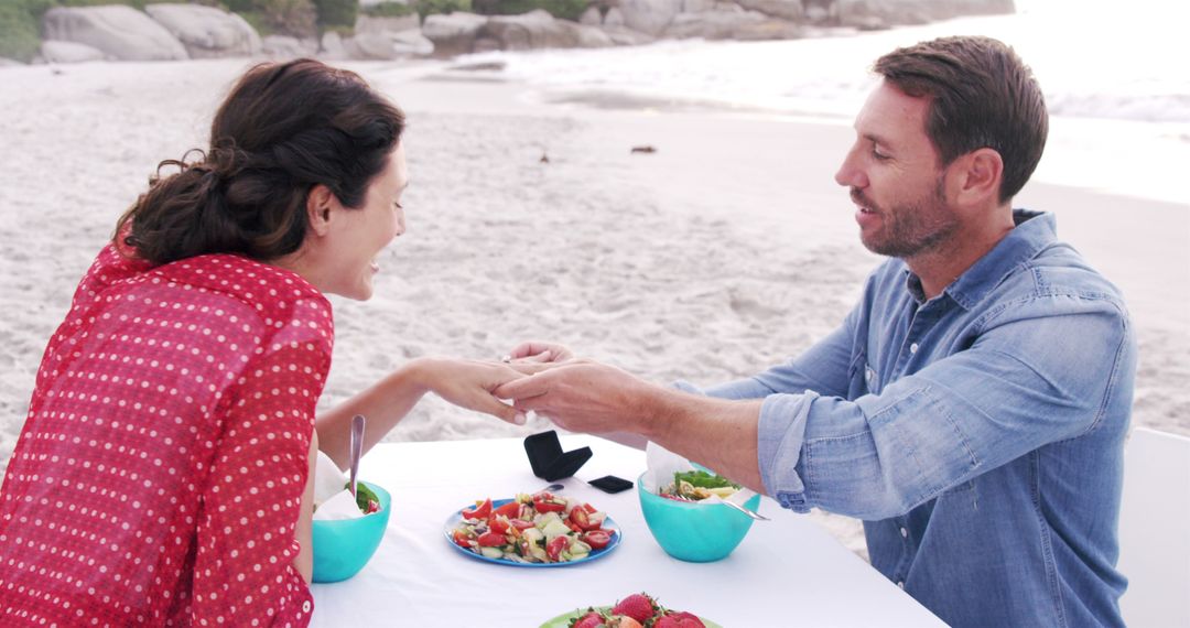 Man Proposing to Woman During Romantic Beach Picnic - Free Images, Stock Photos and Pictures on Pikwizard.com