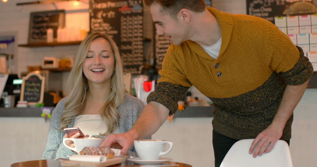 Young Couple Smiling While Sharing Coffee and Pastry in Cozy Cafe - Free Images, Stock Photos and Pictures on Pikwizard.com