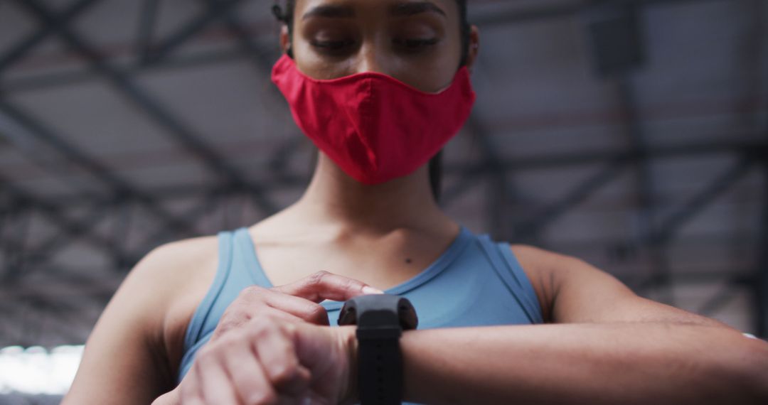 Woman Wearing Mask Checking Smartwatch in Gym - Free Images, Stock Photos and Pictures on Pikwizard.com