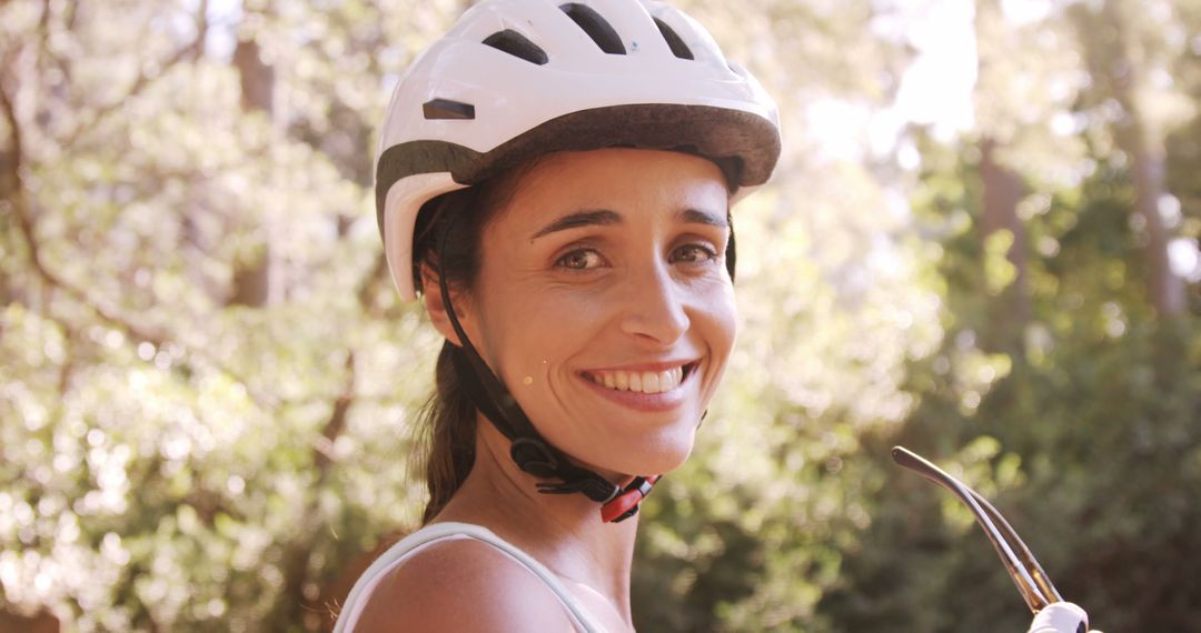 Smiling Woman Wearing Bicycle Helmet Enjoying Nature Outdoors - Free Images, Stock Photos and Pictures on Pikwizard.com