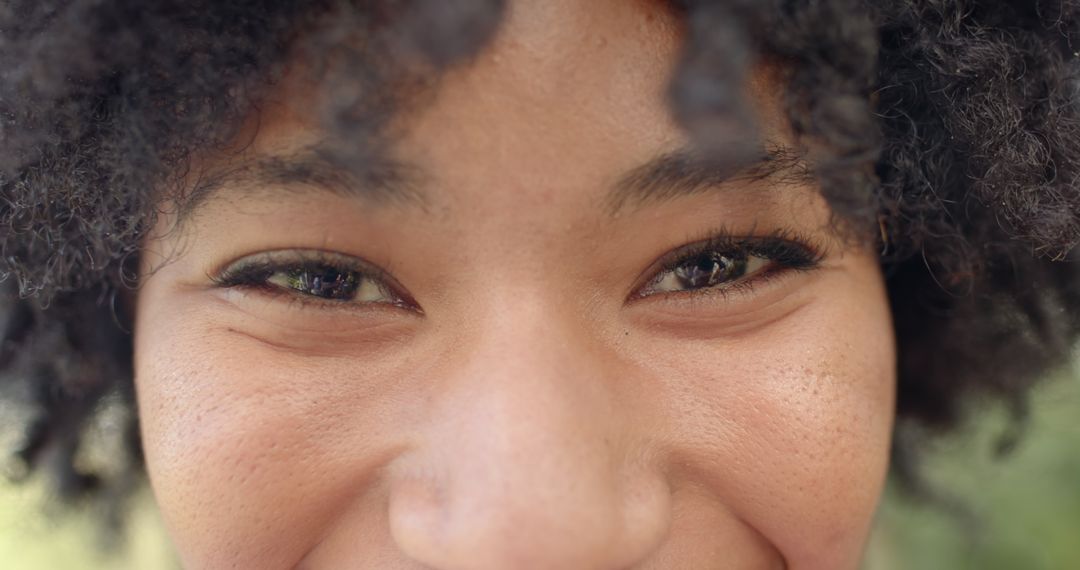 Close-up of Smiling Woman in Sunlight with Natural Curls