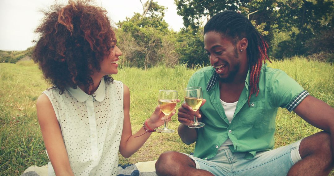 A couple celebrates with a wine toast during a romantic outdoor picnic. - Free Images, Stock Photos and Pictures on Pikwizard.com