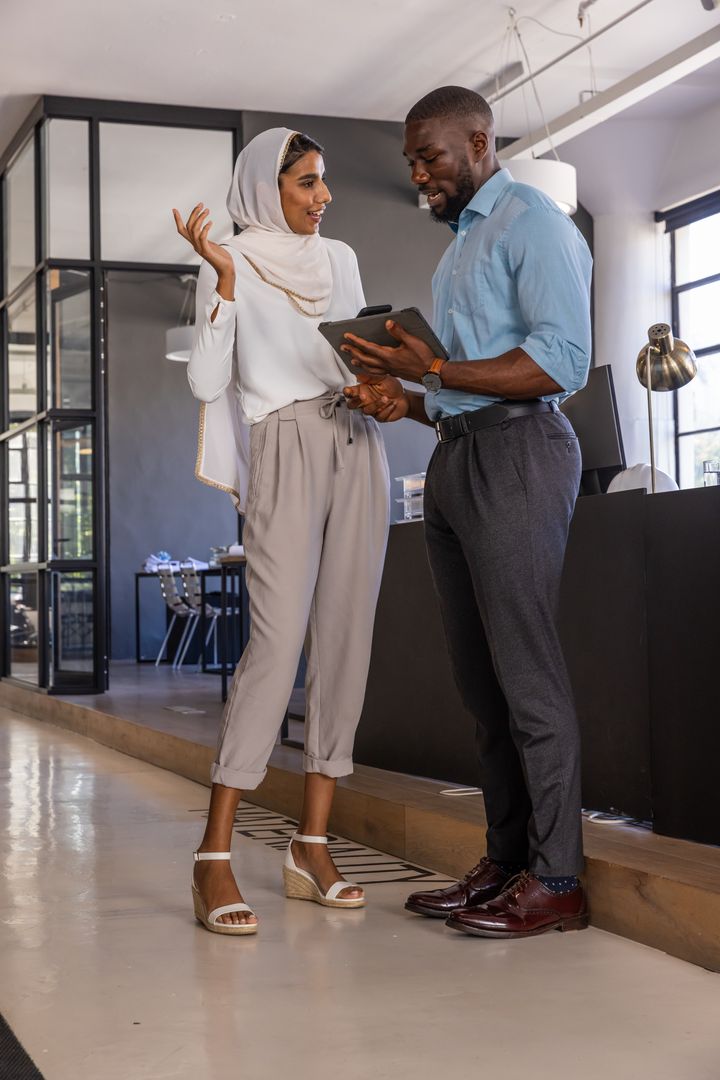 Diverse Coworkers Collaborating with Tablet in Modern Office