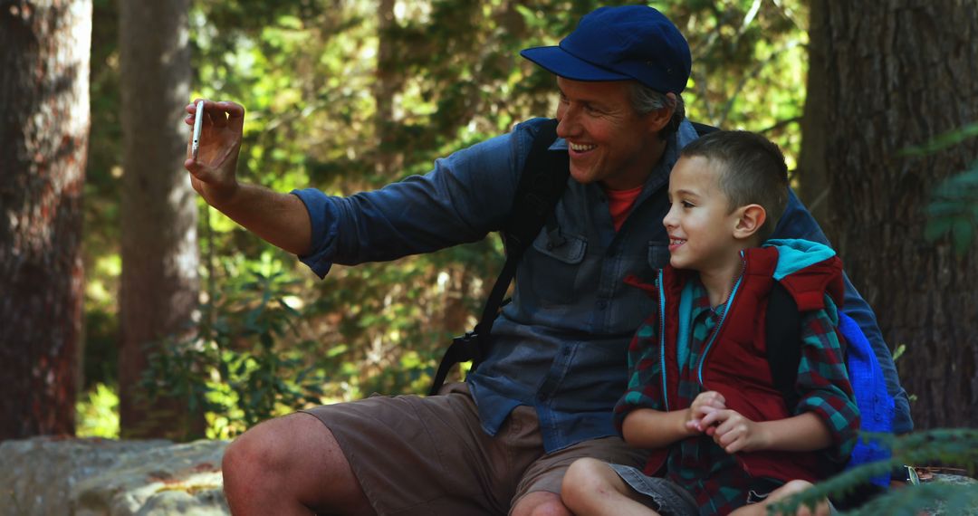 Father and Son Enjoying Hike in Forest Taking Selfie - Free Images, Stock Photos and Pictures on Pikwizard.com