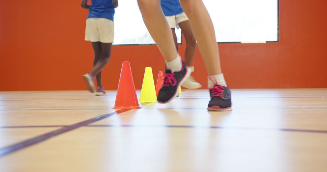 Children Navigating Training Cones in Gym Showing Teamwork and Athleticism