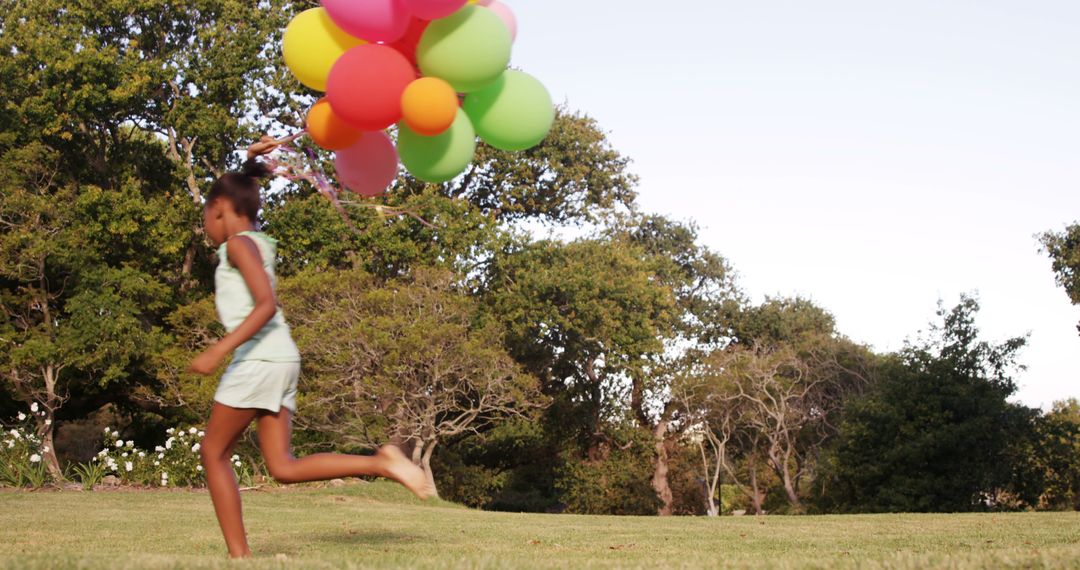 Joyful Girl Running with Balloons in Sunny Park