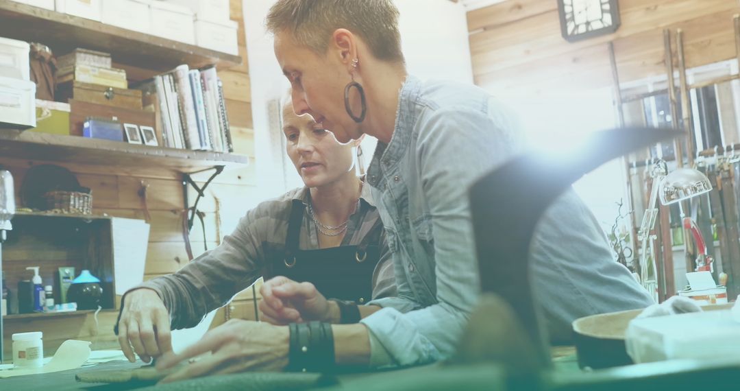 Female Artisans Collaborating in Sunny Workshop with Tablet
