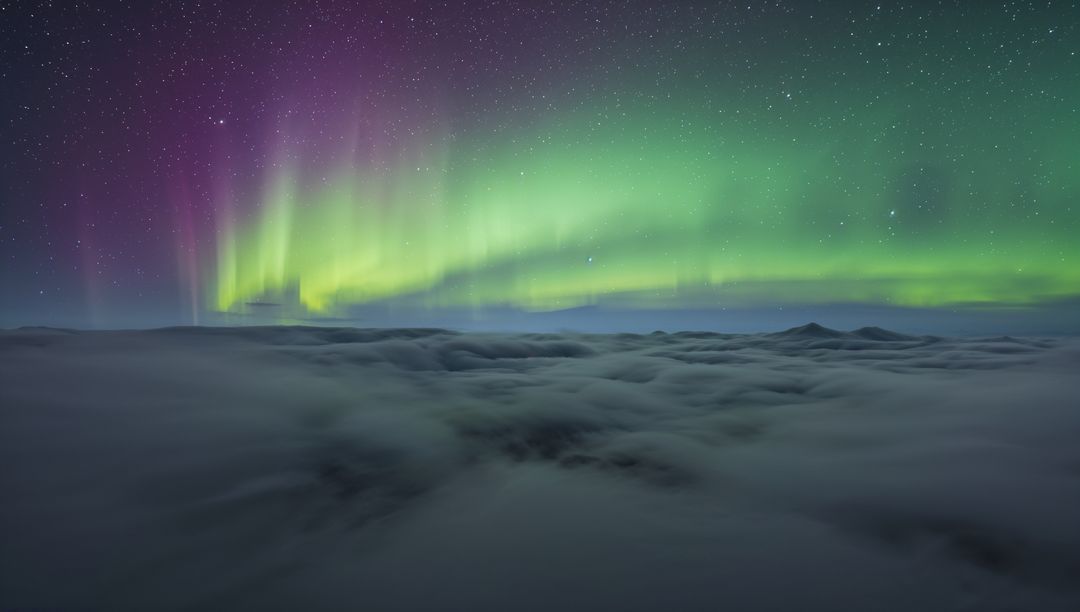 Dancing Aurora Borealis Curtains in Emerald and Violet Over Mountain Cloud Deck
