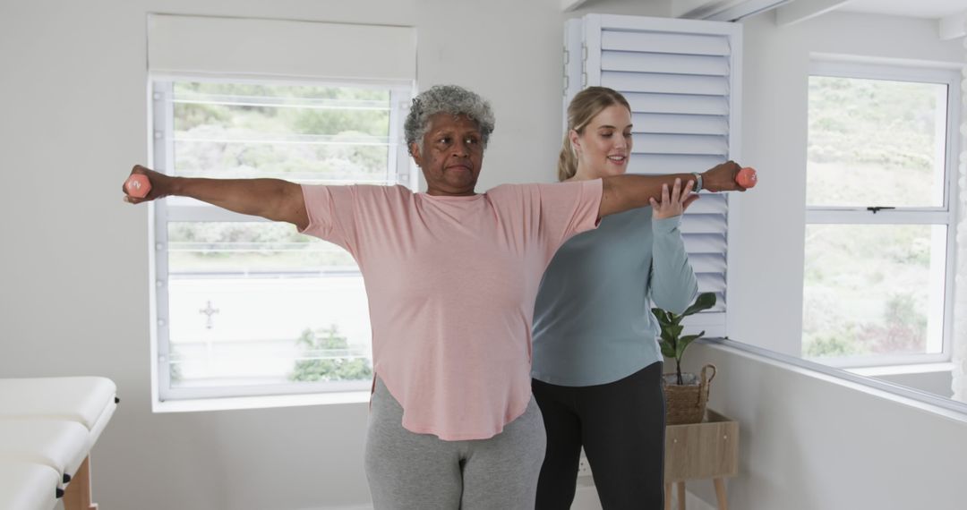 Personal Trainer Assisting Elderly Woman with Arm Exercises at Home - Free Images, Stock Photos and Pictures on Pikwizard.com