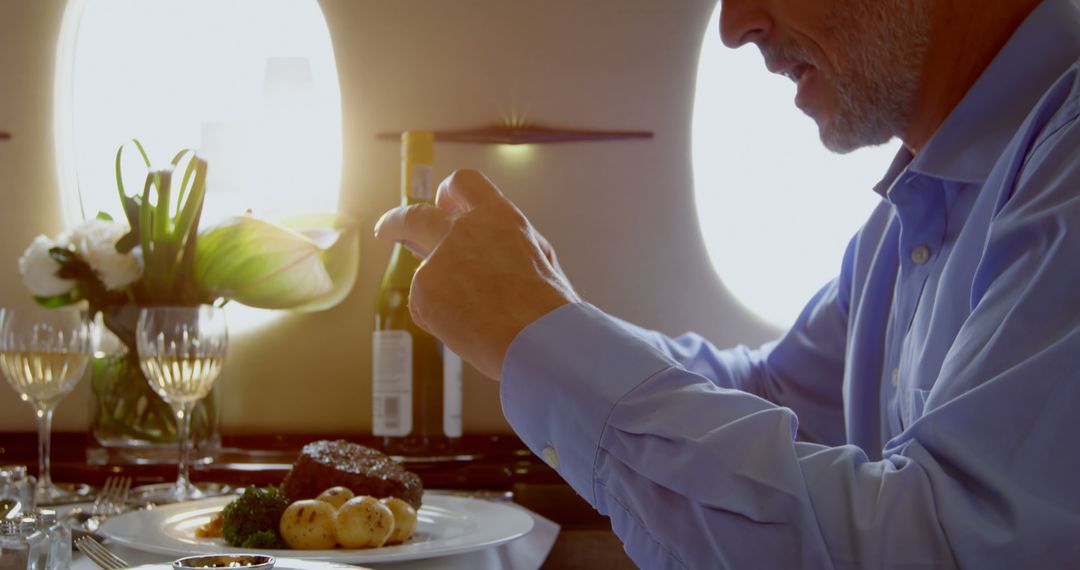 Businessman Dining in Private Jet Taking Photo of Gourmet Meal - Free Images, Stock Photos and Pictures on Pikwizard.com