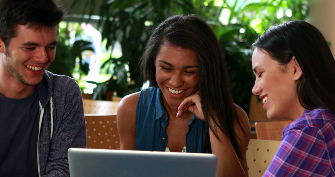 Friends Sharing Laughter While Watching Laptop Content