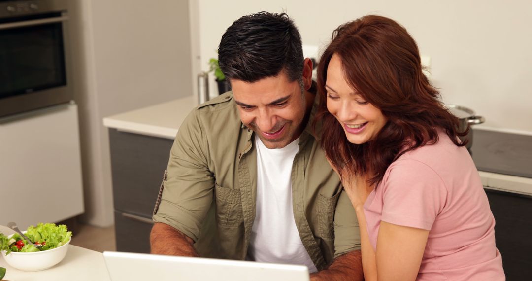 Happy Couple Using Laptop in Modern Kitchen