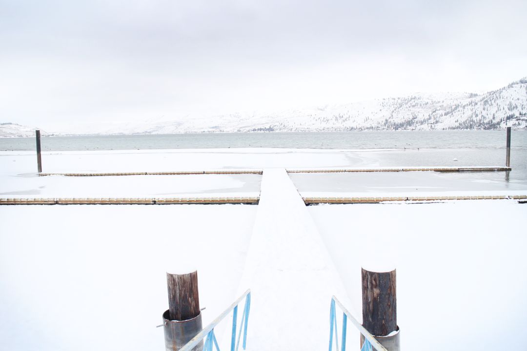 Snowy Pier Extending Into Frozen Lake in Winter Landscape - Free Images, Stock Photos and Pictures on Pikwizard.com