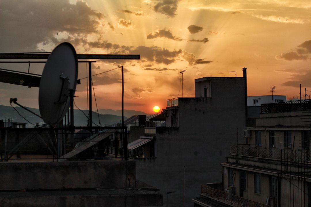 Urban Rooftop Sunset with Satellite Dish in Silhouette - Free Images, Stock Photos and Pictures on Pikwizard.com