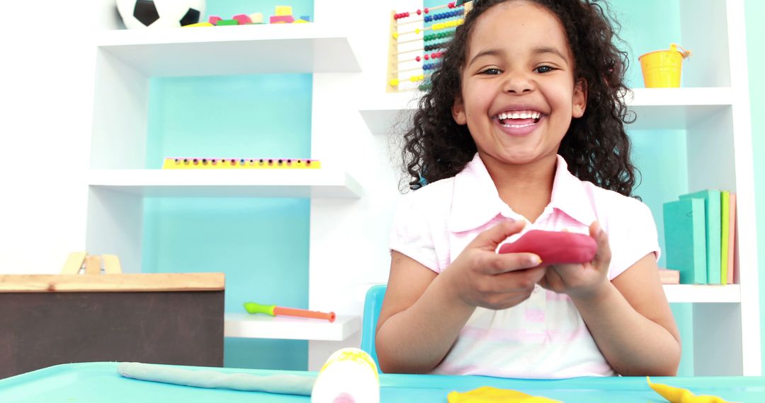 Smiling Child Playing with Modeling Clay in Bright Classroom - Free Images, Stock Photos and Pictures on Pikwizard.com