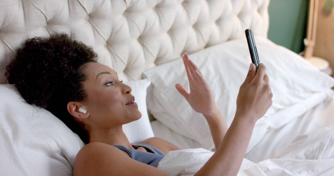 Woman Video Calling on Smartphone While Lying in Bed - Free Images, Stock Photos and Pictures on Pikwizard.com