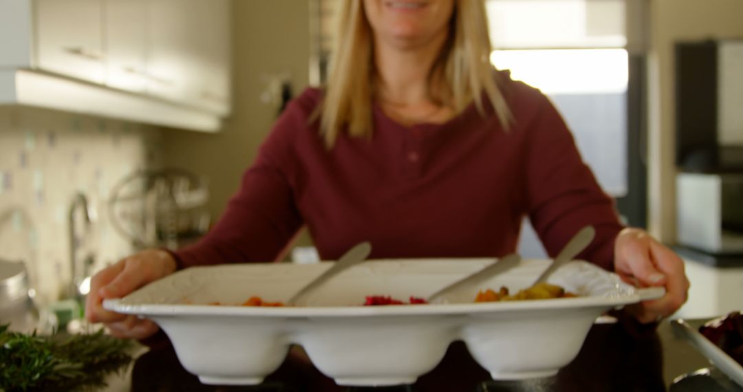 Woman Holding Tray of Vegetables in Kitchen - Free Images, Stock Photos and Pictures on Pikwizard.com