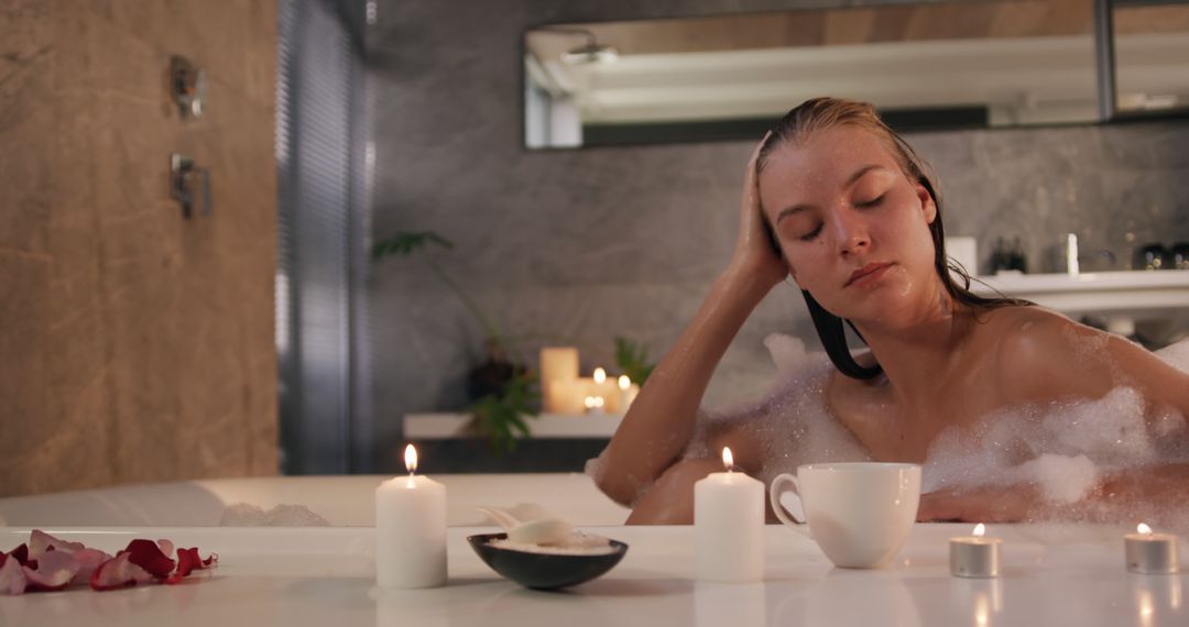 Woman enjoying relaxing bubble bath with candles and cup of tea - Free Images, Stock Photos and Pictures on Pikwizard.com