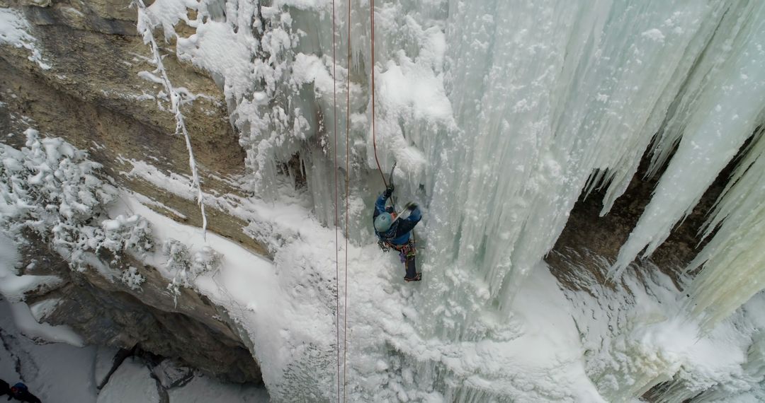 Person Ice Climbing on Frozen Waterfall in Winter Landscape - Free Images, Stock Photos and Pictures on Pikwizard.com