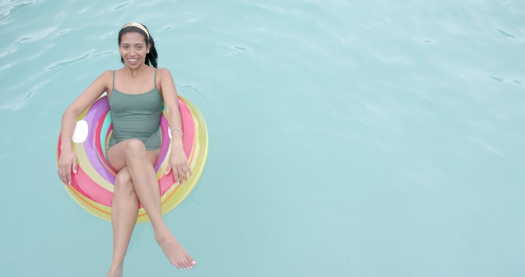 Woman Relaxing on Colorful Pool Float in Clear Water