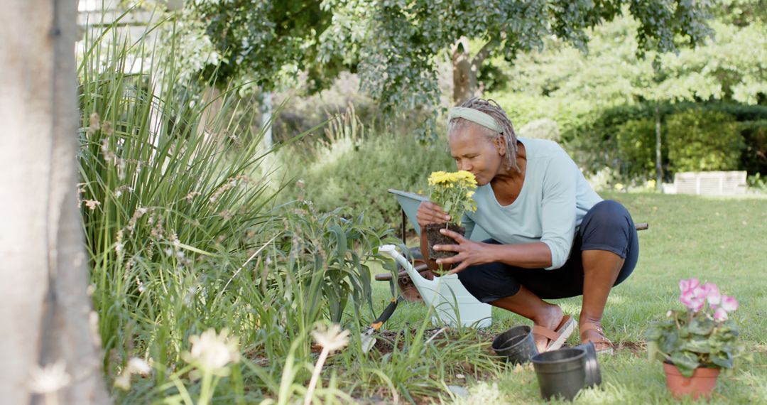 Senior Female Gardener Planting Yellow Flowers in Garden - Free Images, Stock Photos and Pictures on Pikwizard.com