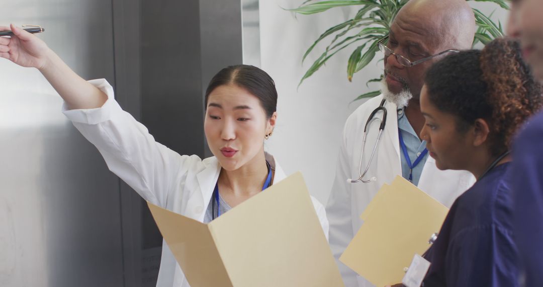 Diverse Medical Team Reviewing Patient Files in Hospital - Free Images, Stock Photos and Pictures on Pikwizard.com