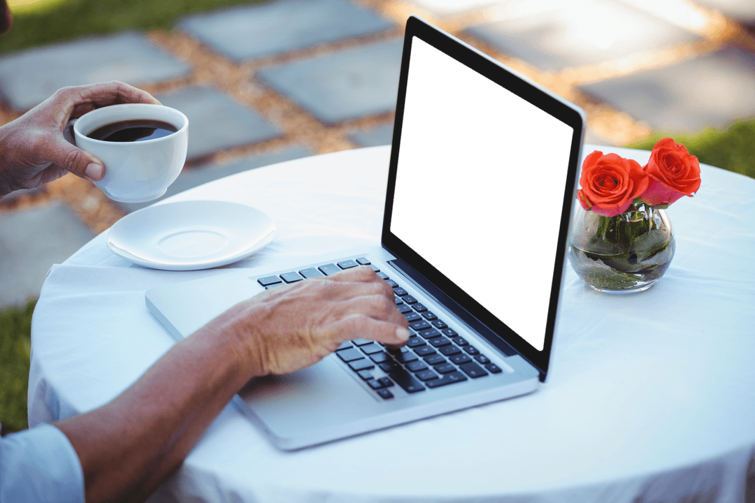 Person Using Laptop and Drinking Transparent Cup of Coffee Outdoors