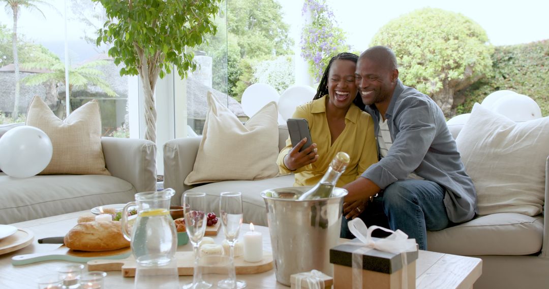 Joyful Couple Celebrating with Gifts and Refreshments at Home