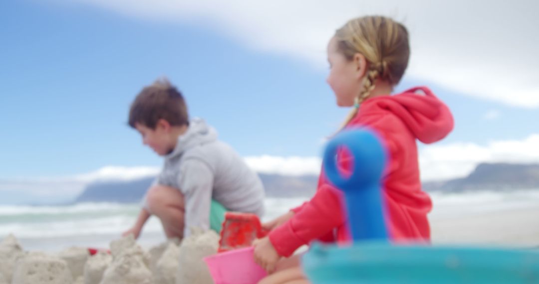 Children Building Sandcastles at Beach on Sunny Day - Free Images, Stock Photos and Pictures on Pikwizard.com