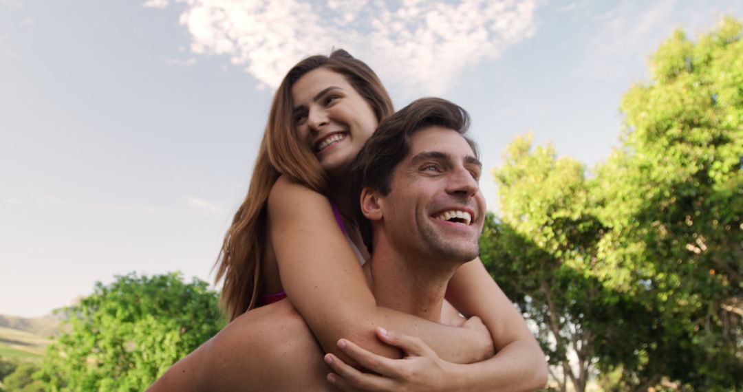 Joyful Couple Piggybacking in Lush Garden Setting