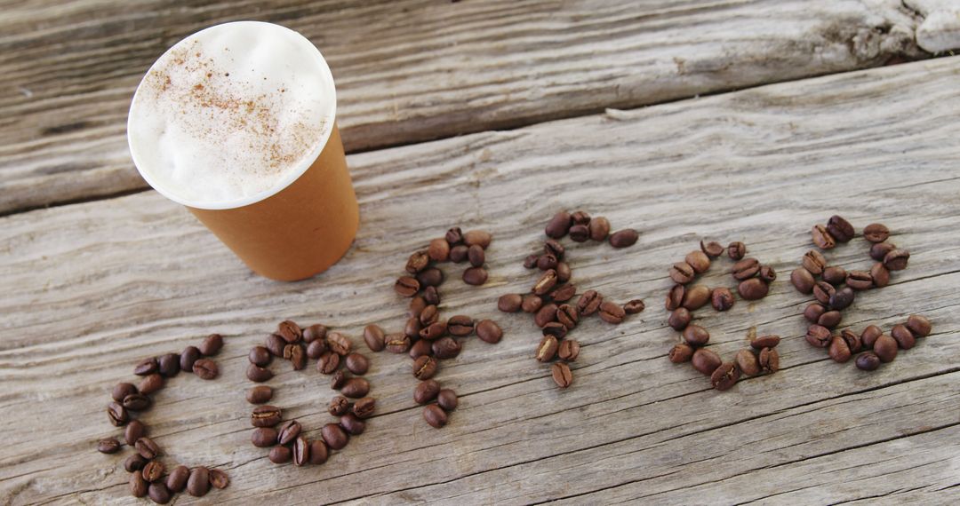 A cappuccino and LOVE spelled in coffee beans on wood convey a caffeinated affection. - Free Images, Stock Photos and Pictures on Pikwizard.com