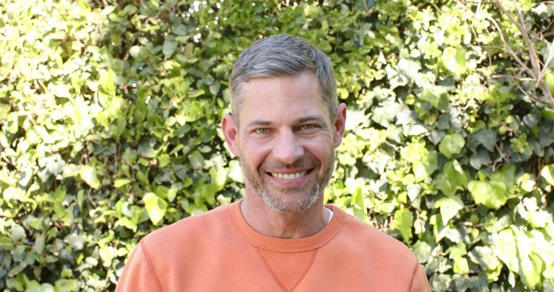 Smiling Man with Graying Hair Outdoors in Orange Sweater - Free Images, Stock Photos and Pictures on Pikwizard.com