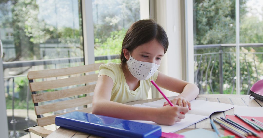 Girl in Face Mask Doing Homework Safely at Home - Free Images, Stock Photos and Pictures on Pikwizard.com