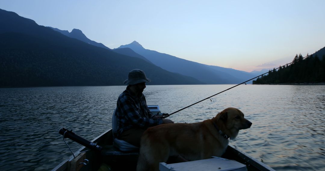 Man and Dog Fishing on Mountain Lake at Dusk - Free Images, Stock Photos and Pictures on Pikwizard.com