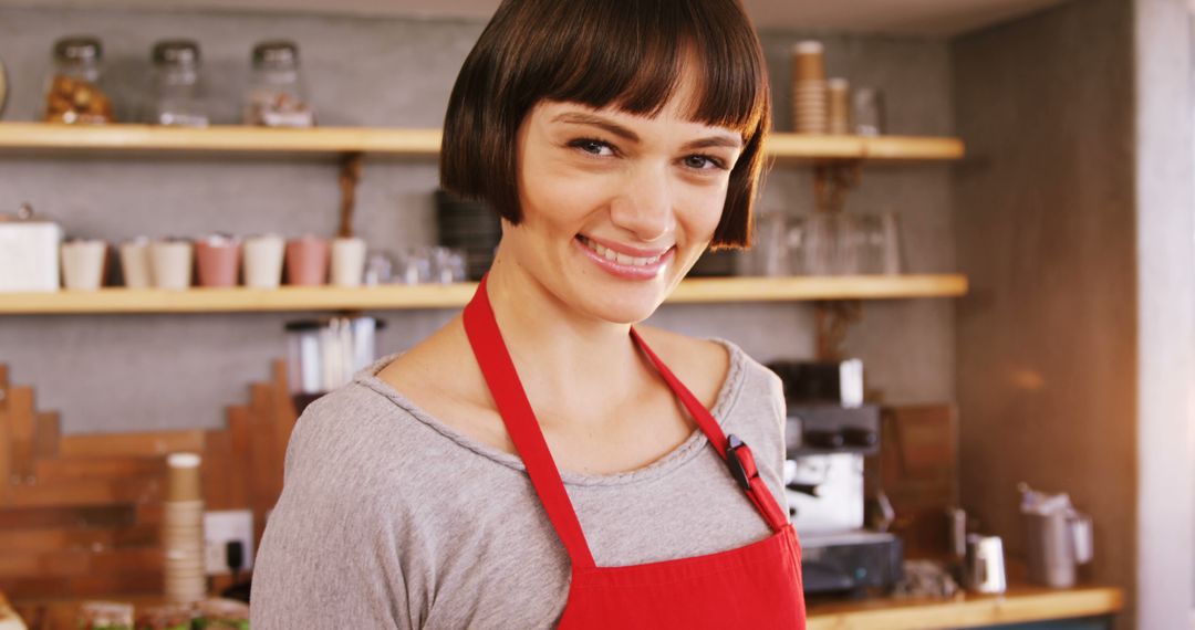 Smiling Female Barista Wearing Red Apron in Coffee Shop - Free Images, Stock Photos and Pictures on Pikwizard.com