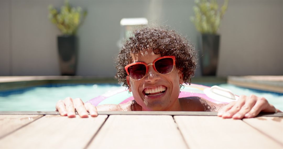 Smiling Man Relaxing in Swimming Pool on Sunny Day