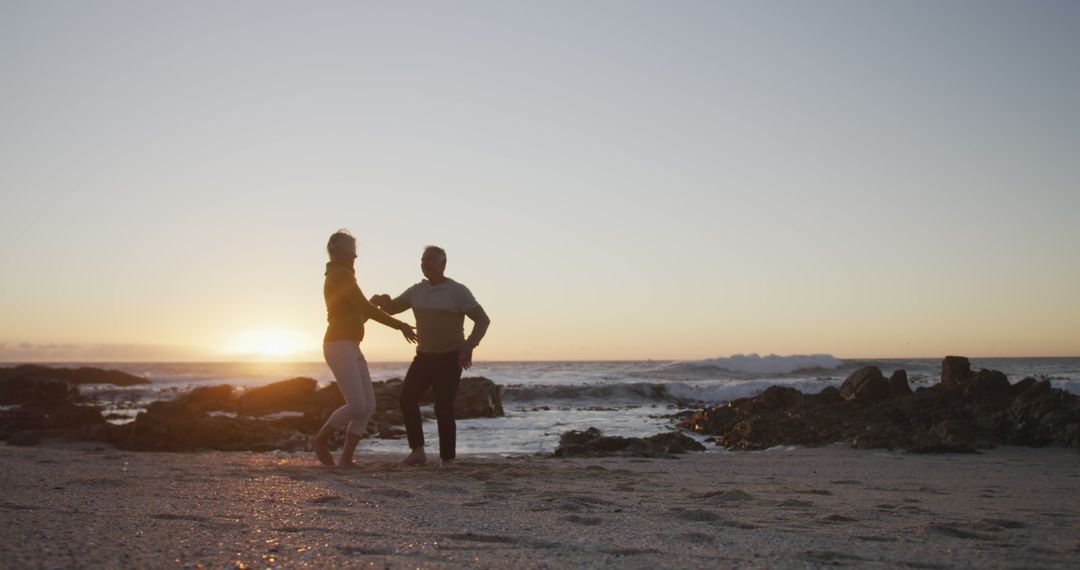 Senior couple dancing by ocean at sunset - Free Images, Stock Photos and Pictures on Pikwizard.com