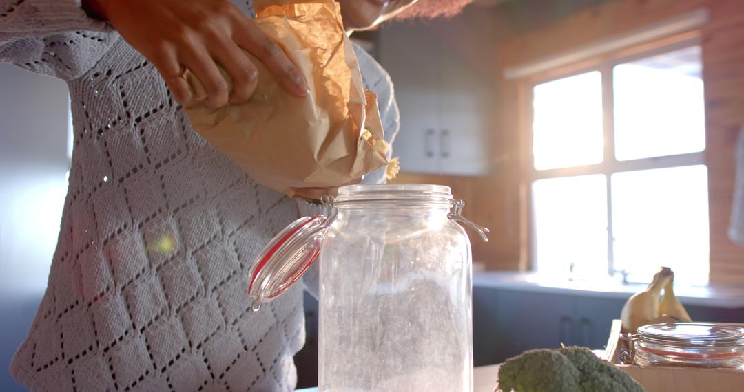 Unrecognizable Person Pouring Ingredients into Glass Jar in Sunlit Kitchen - Free Images, Stock Photos and Pictures on Pikwizard.com