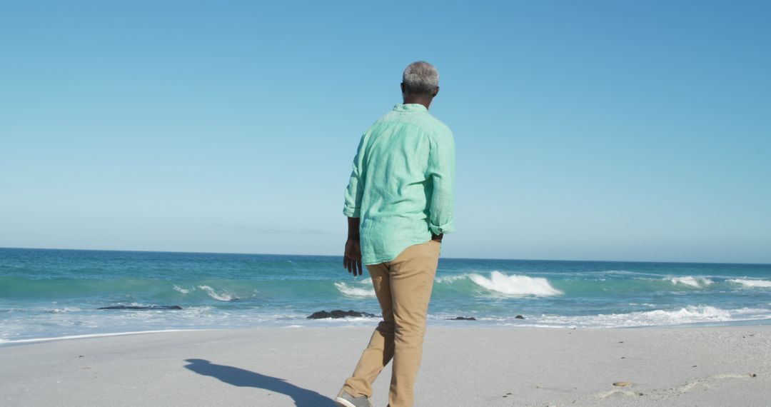 Senior Man Walking on Beach Enjoying Ocean View - Free Images, Stock Photos and Pictures on Pikwizard.com