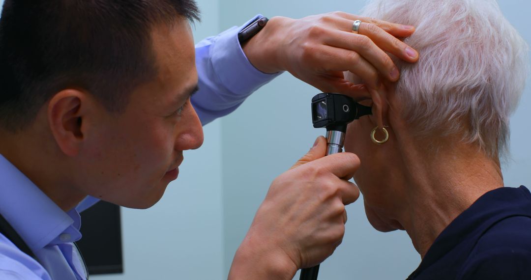 Doctor examining elderly woman with otoscope in clinic - Free Images, Stock Photos and Pictures on Pikwizard.com