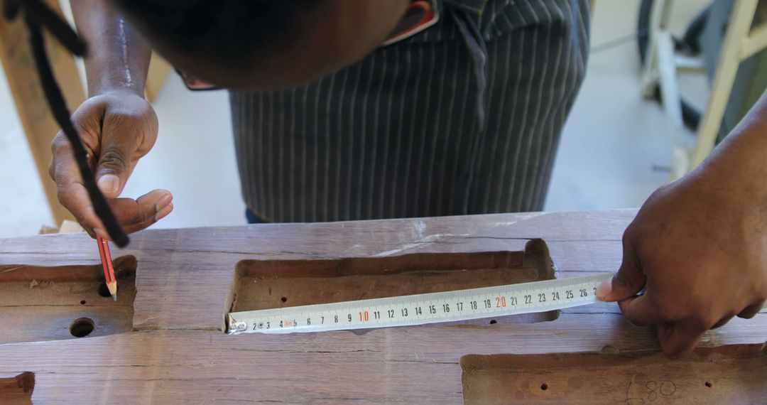 Carpenter Measuring Wood with Tape Measure for Precision - Free Images, Stock Photos and Pictures on Pikwizard.com