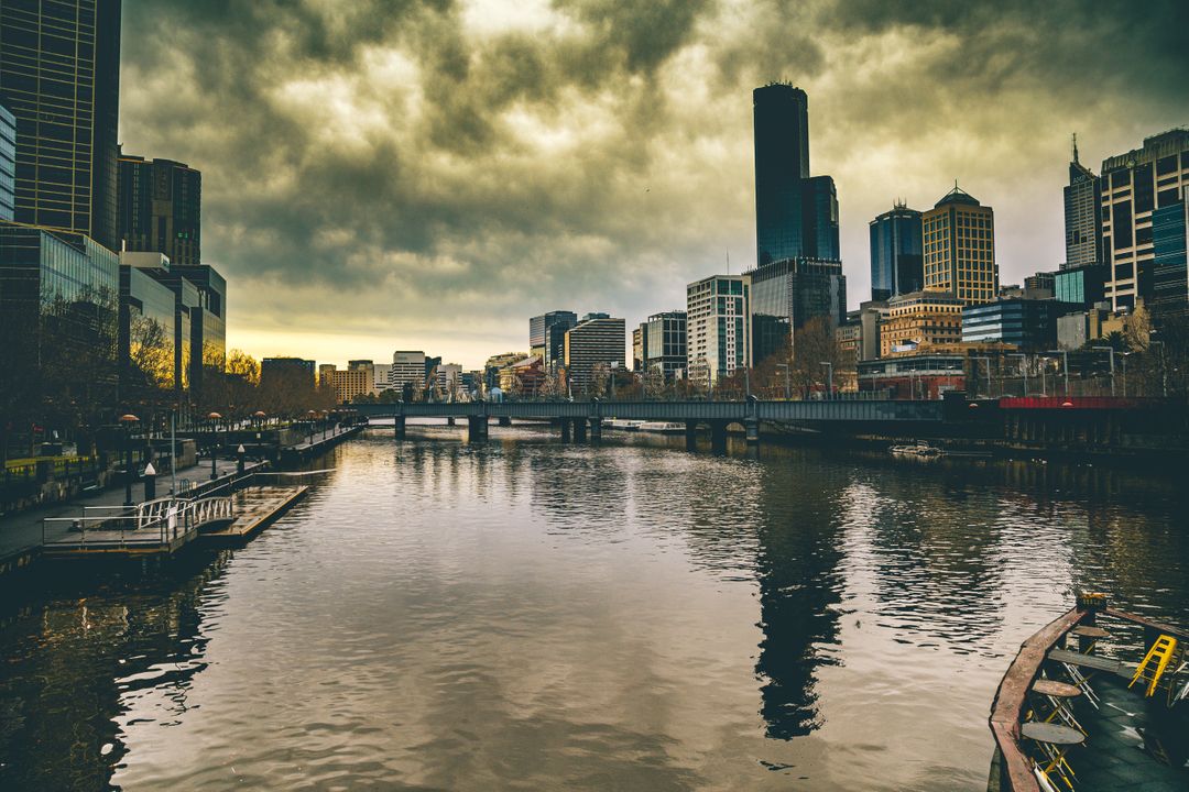 Dramatic Cityscape with Overcast Sky and River Reflection - Free Images, Stock Photos and Pictures on Pikwizard.com