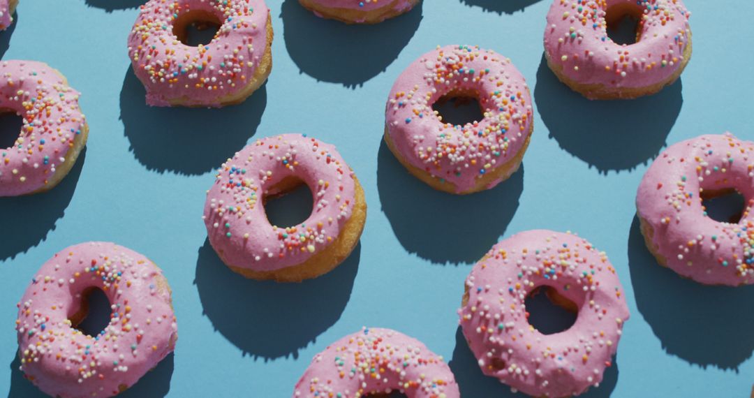 Pattern of Pink Frosted Donuts with Sprinkles on Blue Background - Free Images, Stock Photos and Pictures on Pikwizard.com