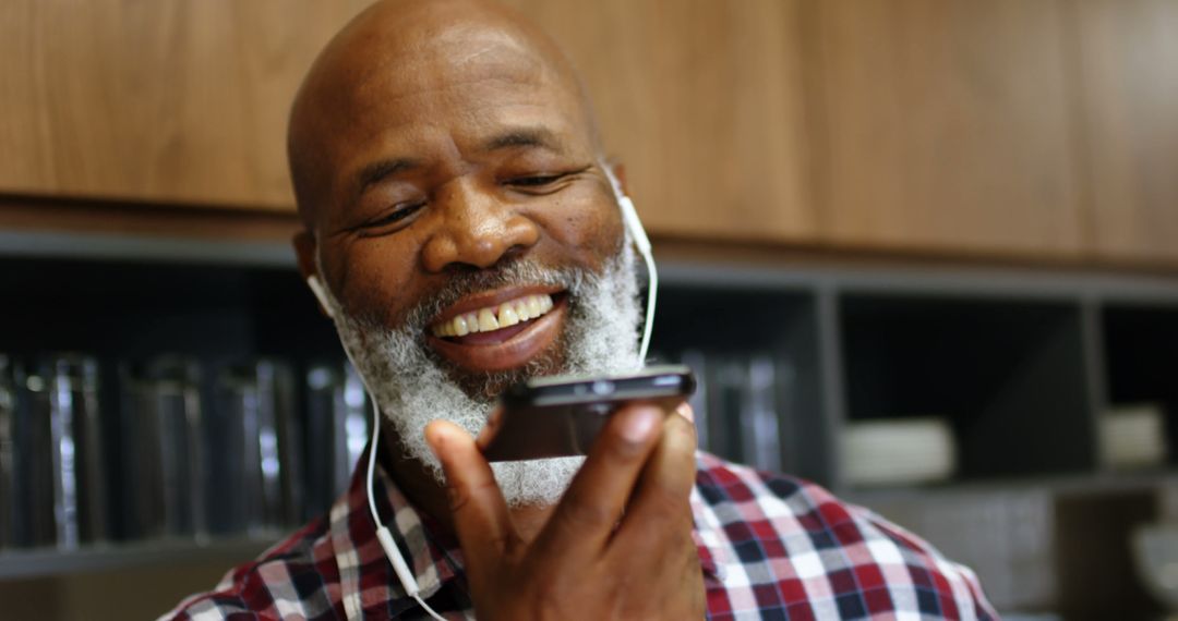 Mature Man with Headphones Using Voice Command on Smartphone - Free Images, Stock Photos and Pictures on Pikwizard.com