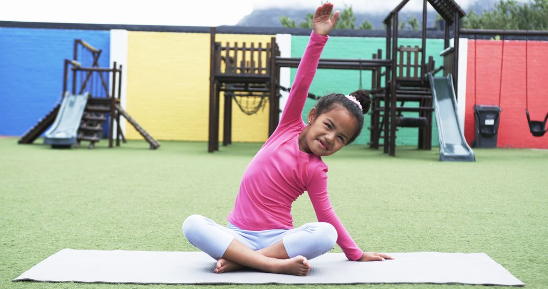 Joyful Girl Exercising on Playground Mat
