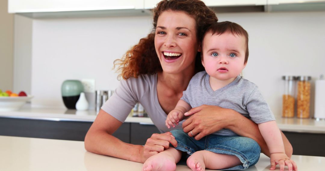 Smiling Mother with Her Baby in Modern Kitchen - Free Images, Stock Photos and Pictures on Pikwizard.com