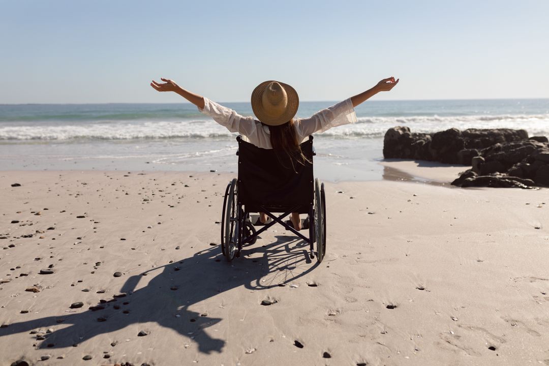 Disabled Woman Enjoying Beach with Arms Outstretched - Free Images, Stock Photos and Pictures on Pikwizard.com