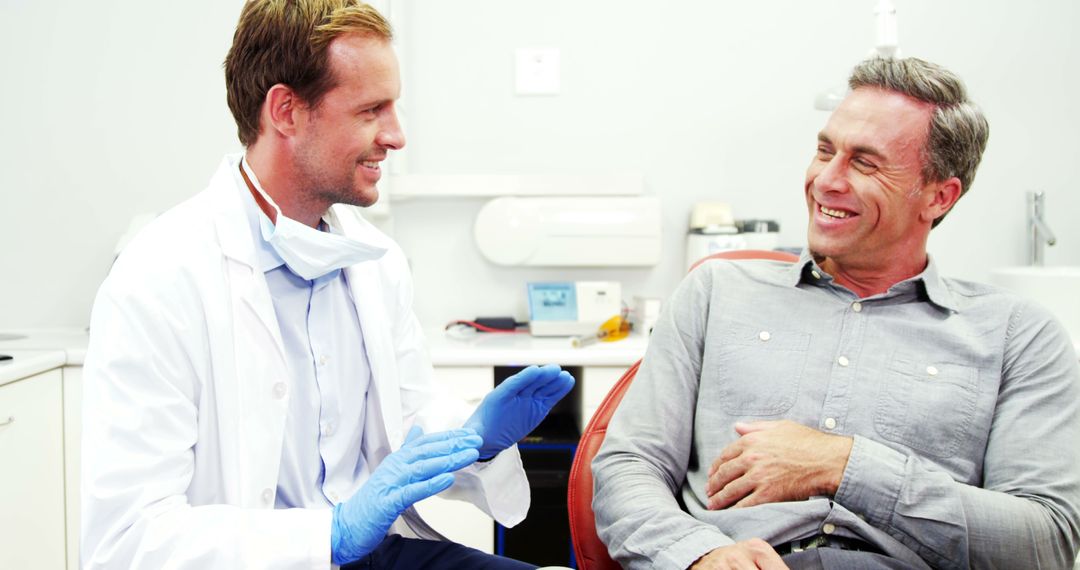 Dentist Consulting Patient In Office with a Smile - Free Images, Stock Photos and Pictures on Pikwizard.com