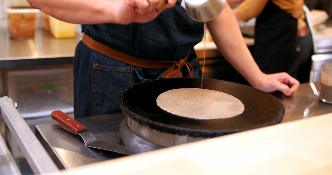 Chef preparing pancake on hot griddle in commercial kitchen - Free Images, Stock Photos and Pictures on Pikwizard.com