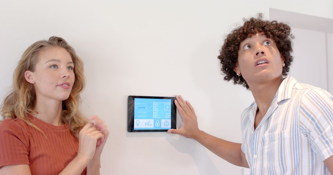 Couple Using Smart Home Control Panel for Automation and Climate Settings